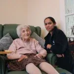 At home care carer giving care from an elderly At Home Care client